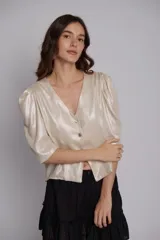 Blusa de lino con acabado metalizado brillante, de corte corto y mangas abullonadas con diseño fluido.