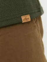Remera de punto canalé francés con cuello polo, manga larga y cierre frontal de metal con tirador personalizado.
