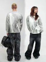 Buzo de punto color gris claro con diseño estampado de siluetas humanas en color blanco. Presenta cuello redondo, mangas largas y un ajuste regular.