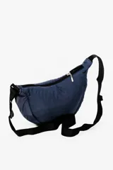 Bandolera color gris claro con forma de media luna, cierre de cremallera y correa ajustable. Incluye etiqueta metálica con el logo de la marca.