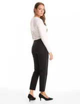 Pantalón slim fit de tiro alto con pretina ancha elastizada y detalle de hilera vertical de micro-tachas metálicas en los laterales. Presenta un diseño sin cierres ni botones, con largo al tobillo y ruedo recto.