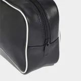 Bolso tipo airliner de Adidas, color negro con ribetes blancos en contraste. Presenta un diseño alargado con textura granulada, asas largas para llevar al hombro y el logo del Trifolio estampado en blanco en el frente. Cuenta con cierre principal y bolsillo interior con cremallera.