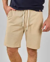 Bermuda color beige confeccionada en lino y algodón, con cordón ajustable en la cintura y bolsillos laterales.