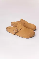 Zueco cerrado de acabado gamuzado color tostado, con una tira ajustable con hebilla metálica en el empeine, plantilla anatómica y base de corcho.