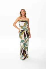 Vestido largo strapless con estampado floral en tonos verdes, marrones y beige. Tiene espalda descubierta con lazo ajustable.