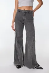 Pantalón de pierna ancha con acabado brillante, confeccionado en lino. Presenta un diseño de tiro medio con cierre de botón y cremallera, bolsillos traseros y etiqueta de marca en la cintura.