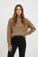 Polera de tejido acrílico azul, de corte holgado, con cuello tipo polera (mock neck) y mangas largas.