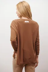 Sweater de tejido de punto color beige, con escote en V y mangas largas. Presenta un diseño básico y versátil de corte recto.
