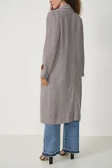 Tapado largo marrón con diseño de espiga, cuello con solapa, cierre con doble botón y bolsillos laterales.