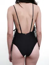 Malla enteriza azul petróleo con textura acanalada, escote en V, breteles finos y lazos laterales ajustables.