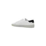 Championes Saint Laurent Court Classic SL/06 de cuero blanco con detalles en negro, incluyendo el talón y el logotipo bordado en el lateral. Suela de goma texturizada.