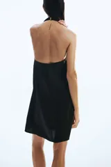 Minivestido halter de satén color negro, de corte holgado y diseño fluido con escote drapeado.