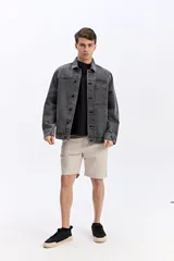 Campera de jean con lavado desgastado, de estructura recta, manga larga y bolsillos amplios en el frente con cierre de botones metálicos.