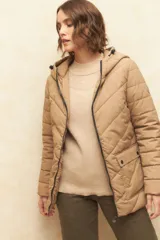 Campera puffer color verde oliva, con capucha, cierre frontal, bolsillos laterales con solapa y elástico en la cintura.