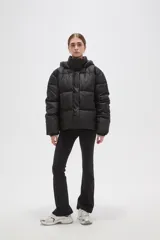 Campera puffer color beige con diseño capitoneado, capucha integrada y cierre frontal oculto. Presenta bolsillos laterales y un corte holgado.