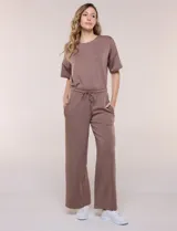 Conjunto de buzo de manga corta con hombros caídos y escote redondo, acompañado de un pantalón tipo wide leg de tiro alto con cintura elástica y cordón de ajuste, en color verde.
