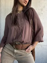 Blusa marrón chocolate de corte oversize, con mangas largas y detalles de encaje y botones forrados en el frente.