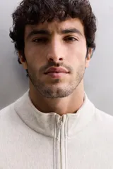 Sudadera gris claro de algodón con interior de rizo, cuello alto con cremallera, manga larga, bolsillos laterales y logo estampado en el pecho.