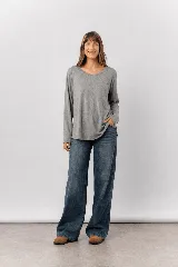 Remera básica de manga larga color gris melange, con escote redondo amplio y calce relajado de caída fluida.
