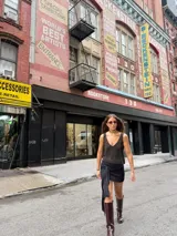 Minifalda ajustada de tejido de punto color marrón oscuro, con detalle de lazo o nudo en el lateral.