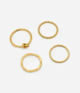 Set de cuatro anillos finos de acero inoxidable en color dorado. El kit incluye un anillo con diseño de nudo, uno de estilo trenzado, uno liso con forma orgánica y uno con acabado texturizado.