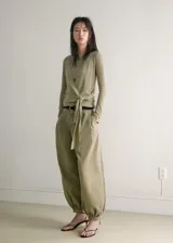 Cardigan cruzado de punto fino en color verde militar, con cuello en V, manga larga y cierre de lazo lateral.