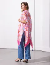 Kimono tejido con estampado abstracto en tonos naranja, rosa y blanco, con mangas amplias estilo japonés y terminación con borlas.