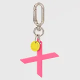 Llavero con dije en forma de letra A color rosado y pequeño dije circular amarillo con logo de la marca grabado. Incluye gancho metálico tipo mosquetón.