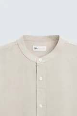 Camisa negra de lino y algodón, corte relaxed fit, cuello mao, manga larga con puños abotonados y cierre frontal con botones.