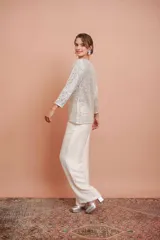 Pantalón palazzo color crudo con textura arrugada y cintura elástica.