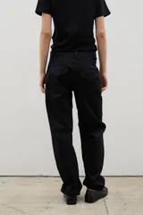 Pantalón de gabardina con corte barrel, diseño holgado y tiro medio. Cuenta con cierre frontal y bolsillos laterales.