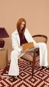 Billetera de mano tipo sobre con correa de muñeca, confeccionada en material sintético color suela. Presenta un diseño rectangular con cierre frontal y compartimentos internos para tarjetas y monedas.