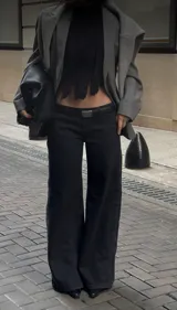 Jeans wide leg de denim rígido, tiro bajo y color negro.