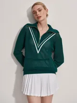 Sweater de punto verde oscuro con cierre dorado y cuello polo. Presenta un diseño en V blanco en el pecho.