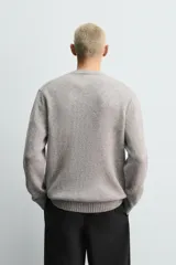 Jersey de punto con hilatura de lana, corte regular fit, cuello redondo y manga larga con acabados en rib.