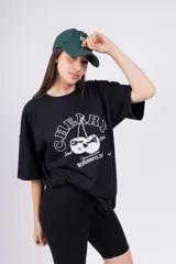 Remerón blanco de corte holgado con estampado de cerezas y texto en color rosa.