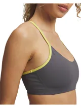 Top deportivo de bajo impacto con diseño de espalda cruzada, confeccionado en tejido elástico con perforaciones para mayor transpirabilidad. Presenta un diseño bicolor en gris con ribetes en color amarillo neón.