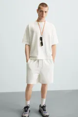 Bermuda de algodón gris con efecto lavado, corte relajado, cintura elástica ajustable con cordón y bolsillos laterales y trasero de vivo.