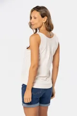 Musculosa blanca sin mangas, de corte clásico y calce cómodo, confeccionada en tejido suave. Presenta escote redondo, cartera con botones frontales y un pequeño bolsillo aplicado en el pecho.