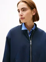 Campera bomber azul marino acolchada con cuello de béisbol, cierre frontal con cremallera, dos bolsillos laterales ribeteados en diagonal y puños y cuello de punto canalé.