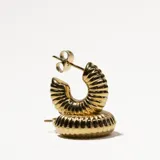 Par de aros tipo argolla gruesa, dorados, con textura acanalada.