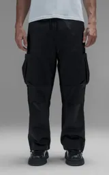 Pantalón cargo de corte regular confeccionado en textil técnico pesado. Presenta cintura elástica con cordón de ajuste, bolsillos laterales en la cintura y bolsillos cargo de gran tamaño en los muslos. Incluye elásticos con tancas en los tobillos para regular la apertura de la pierna.