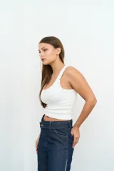 Jean wide leg de tiro medio, confeccionado en denim azul oscuro con paneles laterales en tono denim más claro. Cuenta con diseño de doble botón en la pretina, bolsillos delanteros y corte amplio en las piernas.