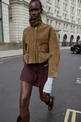 Bermuda de tiro alto color negro, con diseño de tablas frontales y detalle de eslabones metálicos dorados en la cintura. Cuenta con cierre lateral oculto.