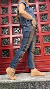 Pantalón de diseño híbrido que combina denim azul oscuro con paneles laterales de cuero en tono chocolate. Presenta un corte recto y cintura de altura media.