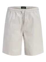 Bermuda de calce relajado color beige, con cintura elástica con cordón de ajuste, bolsillos delanteros y traseros, confeccionada en tejido dobby con textura sutil y un toque de elasticidad.