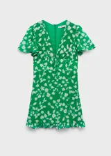 Vestido corto de tejido fluido color verde con estampado floral en tono crema. Presenta escote en pico con cierre de lazo frontal, mangas cortas con vuelo, diseño entallado en la cintura y bajo con volante.