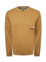 Buzo de algodón orgánico color naranja tostado, con cuello redondo y apertura frontal con broches a presión. Presenta un bolsillo pequeño en el pecho con parche decorativo y mangas largas.