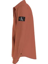 Camisa color ladrillo de corte relaxed, confeccionada en sarga de algodón elástico. Tiene cuello en punta, cierre de botones, puños redondos y bajo recto.