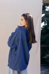 Camisa de denim suave con lavado clásico, corte oversize, cuello camisero y cierre frontal con botones a contraste.